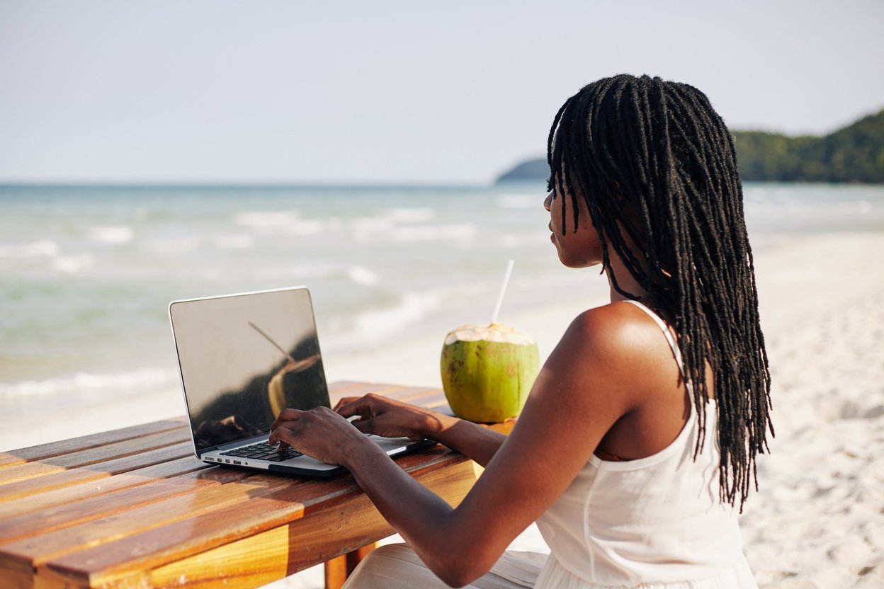 Young Woman Working on Computer on Beach