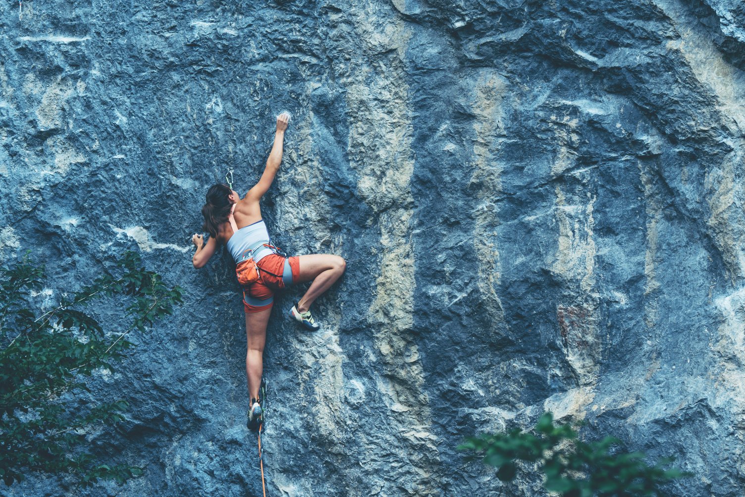 Woman climbs a rock.